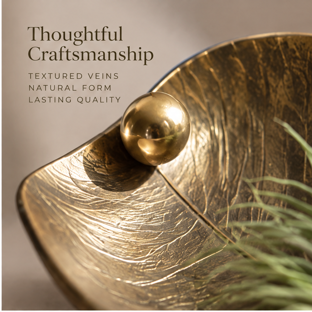 Gold-tone leaf tray showing its textured veins, curled tip and air plant