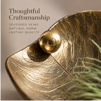 Gold-tone leaf tray showing its textured veins, curled tip and air plant