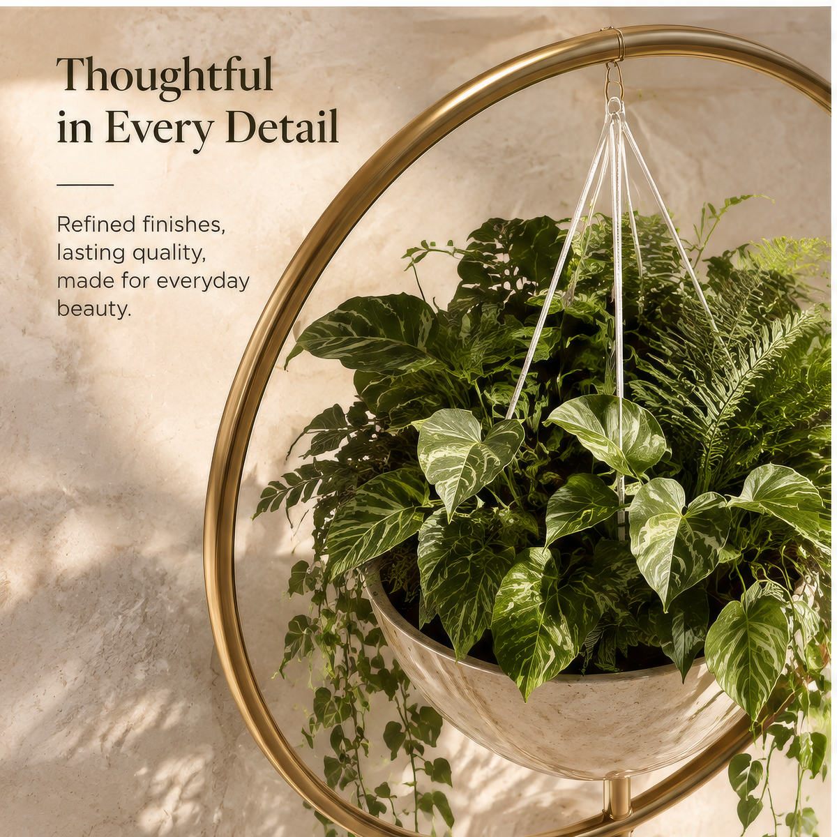 Circular gold-tone plant display with suspended cream bowl and trailing greenery