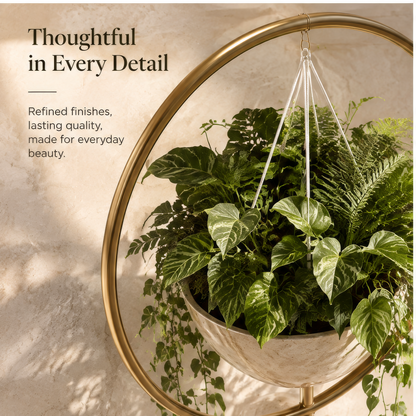 Circular gold-tone plant display with suspended cream bowl and trailing greenery